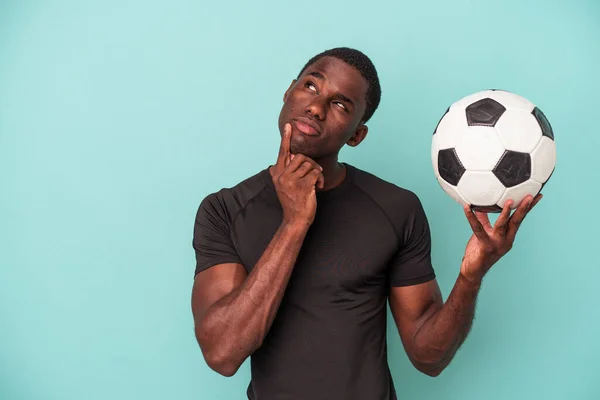 Giovane Uomo Afroamericano Che Gioca Calcio Isolato Sfondo Blu Guardando — Foto Stock