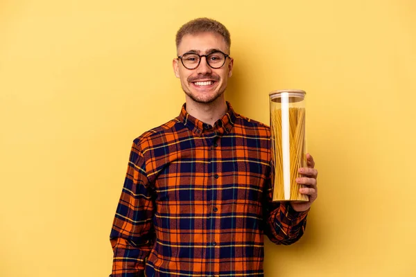 Young Caucasian Man Holding Spaghettis Jar Isolated Yellow Background Happy — Stock fotografie