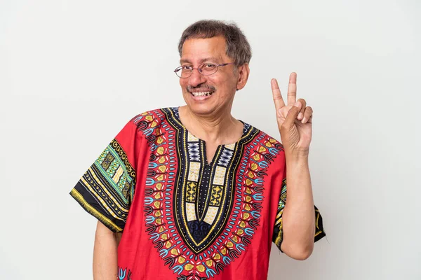 Senior indian man wearing a Indian costume isolated on white background joyful and carefree showing a peace symbol with fingers.
