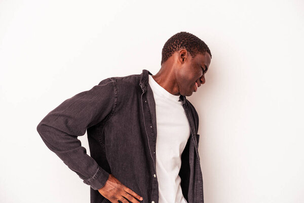 Young African American man isolated on white background suffering a back pain.