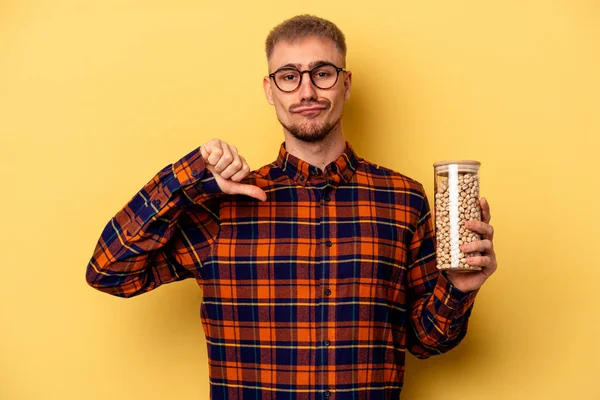 Young Caucasian Man Holding Chickpeas Isolated Yellow Background Feels Proud — Stock fotografie