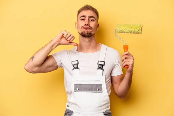 Young painter man isolated on yellow background feels proud and self confident, example to follow.