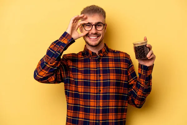 Young Caucasian Man Holding Coffee Jar Isolated Yellow Background Excited — Stock fotografie