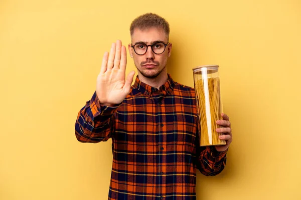 Young Caucasian Man Holding Spaghettis Jar Isolated Yellow Background Standing — Stock fotografie
