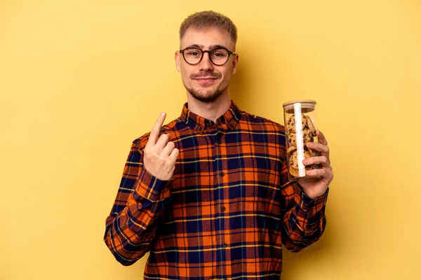 Young Caucasian Man Holding Cookies Jar Isolated Yellow Background Pointing — Stock fotografie