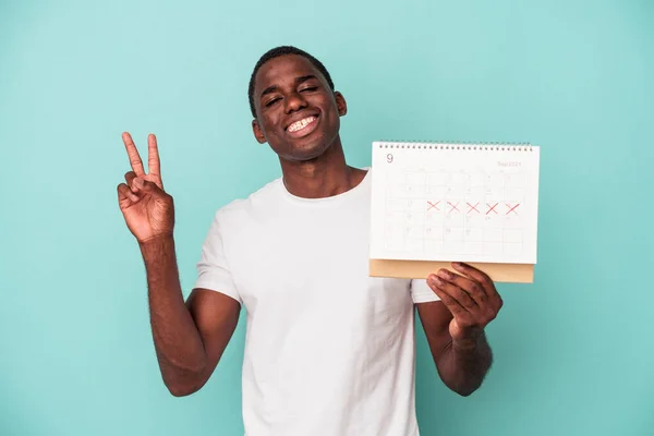 Jonge Afro Amerikaanse Man Met Een Kalender Geïsoleerd Blauwe Achtergrond — Stockfoto