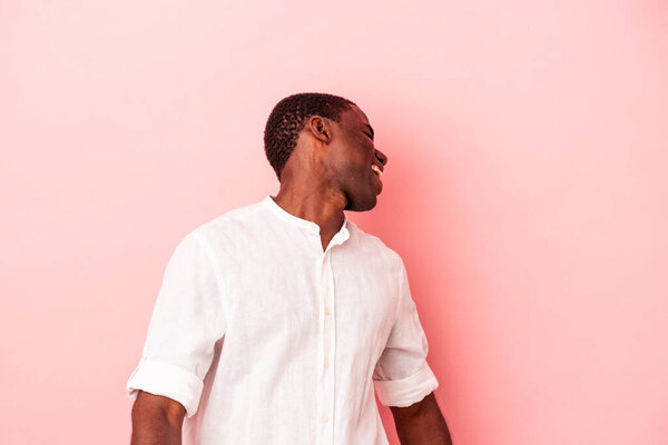 Young African American man isolated on pink background dancing and having fun.