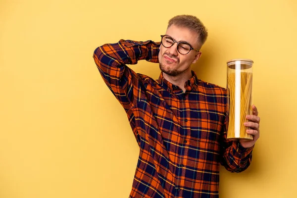 Young Caucasian Man Holding Spaghettis Jar Isolated Yellow Background Touching — 图库照片