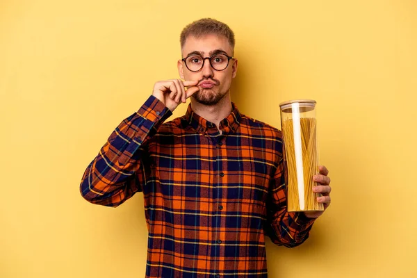 Young Caucasian Man Holding Spaghettis Jar Isolated Yellow Background Fingers — Stock fotografie