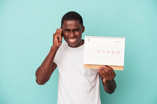 Jonge Afro Amerikaanse Man Met Een Kalender Geïsoleerd Blauwe Achtergrond — Stockfoto