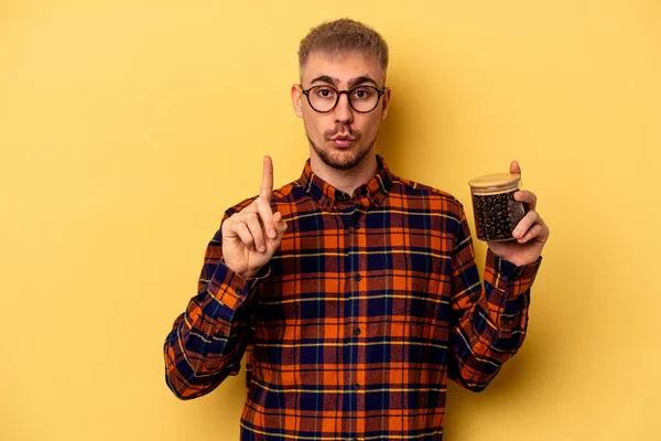 Young Caucasian Man Holding Coffee Jar Isolated Yellow Background Having — Zdjęcie stockowe