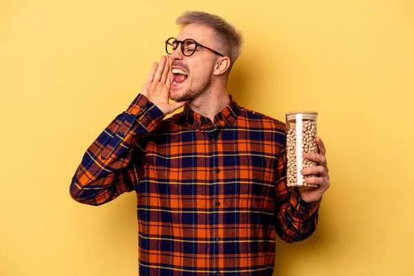 Young Caucasian Man Holding Chickpeas Isolated Yellow Background Shouting Holding — Stockfoto