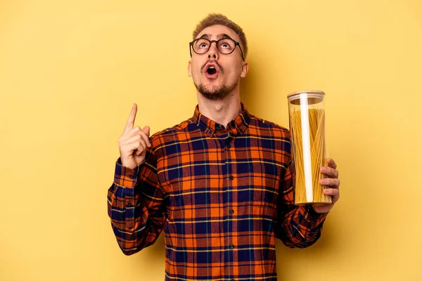 Young Caucasian Man Holding Spaghettis Jar Isolated Yellow Background Pointing — Stock fotografie