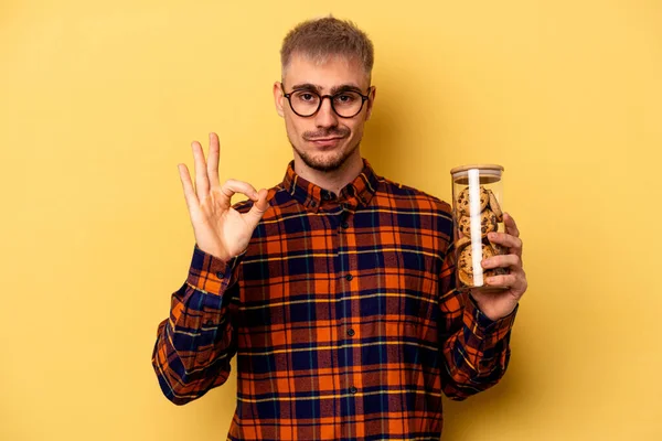 Young Caucasian Man Holding Cookies Jar Isolated Yellow Background Cheerful — Photo