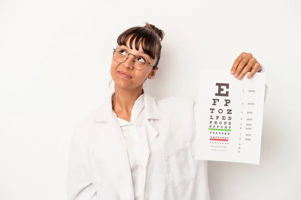 Young mixed race optician woman doing a test isolated on white background  dreaming of achieving goals and purposes
