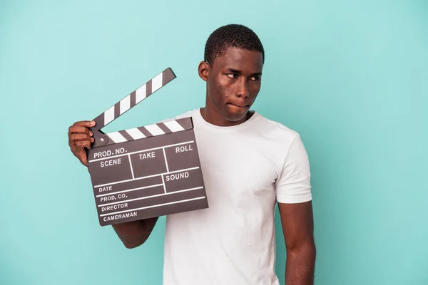 Young African American Man Holding Clapperboard Isolated Blue Background Confused — Stock Photo, Image