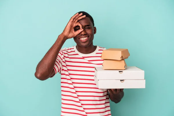 Mladý Afroameričan Drží Pizzy Hamburgery Izolované Modrém Pozadí Vzrušený Udržet — Stock fotografie