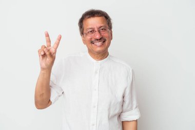 Middle aged indian man isolated on white background joyful and carefree showing a peace symbol with fingers.