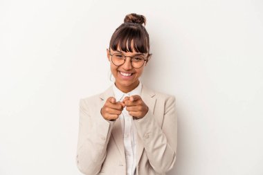 Beyaz arka planda izole edilmiş genç melez kadın parmaklarıyla öne işaret ediyor..