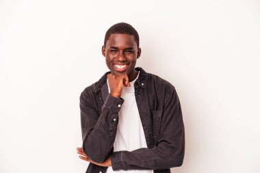 Beyaz arka planda izole edilmiş, mutlu ve kendinden emin gülümseyen, elleriyle çenesine dokunan genç bir Afrikalı Amerikalı..