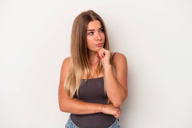 Beyaz arka planda izole edilmiş genç bir Rus kadın şüpheli ve şüpheci bir ifadeyle yana bakıyor..