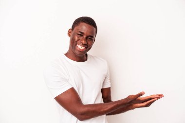 Beyaz arka planda izole edilmiş genç Afro-Amerikalı bir adam bir palmiye üzerinde bir kopya alanı tutuyor..