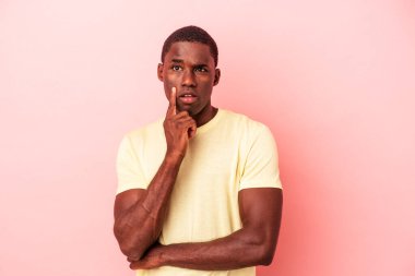 Genç Afrikalı Amerikalı bir adam pembe arka planda izole edilmiş. Harika bir fikri var, yaratıcılık kavramı..