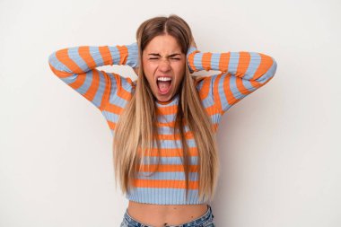 Beyaz arka planda izole edilmiş genç bir Rus kadın. Kulaklarını elleriyle kapatıyor. Çok fazla ses duymamaya çalışıyor..