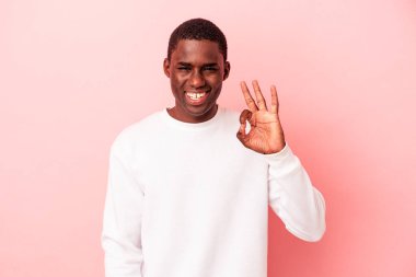Genç Afrikalı Amerikalı adam pembe arka planda izole edilmiş neşeli ve kendinden emin..