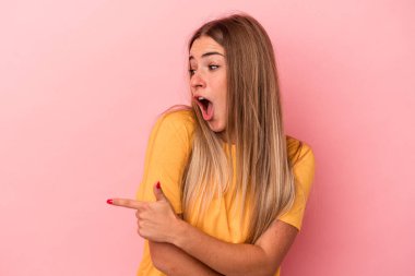 Pembe arka planda izole edilmiş genç bir Rus kadın çok uzaklara bakıyor ve elini alnına koyuyor..