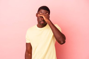 Genç Afrikalı Amerikalı adam pembe arka planda izole edilmiş tapınaklara dokunuyor ve baş ağrısı çekiyor..