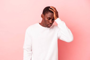 Pembe arka planda izole edilmiş genç Afrikalı Amerikalı adam yorgun ve uykulu..