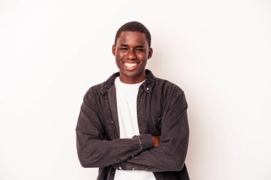 Beyaz arka planda izole edilmiş genç bir Afrikalı Amerikalı. Kendine güveniyor, kararlılıkla kollarını kavuşturuyor..