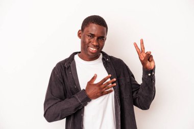 Genç Afrikalı Amerikalı adam beyaz arka planda izole edilmiş bir şekilde yemin ediyor, elini göğsüne koyuyor..