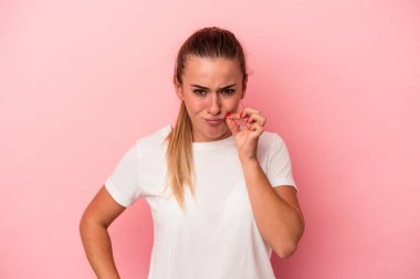 Pembe arka planda izole edilmiş genç Rus kadın parmakları dudaklarında bir sır saklıyor..