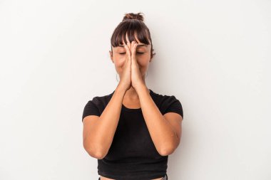 Beyaz arka planda izole edilmiş genç melez bir kadın. El ele tutuşup dua ediyor. Kendine güveniyor..