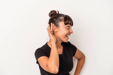 Beyaz arka planda izole edilmiş genç melez kadın bir dedikoduyu dinlemeye çalışıyor..