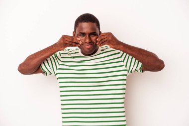 Genç Afrikalı Amerikalı, beyaz arka planda izole edilmiş ve iki seçenek arasında şüphe duyuyor..