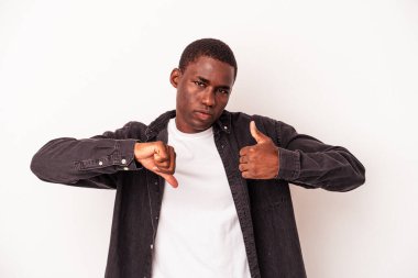Beyaz arka planda izole edilmiş genç Afro-Amerikalı adam baş parmağını kaldırıyor ve baş parmağını aşağı gösteriyor, zor seçim konsepti