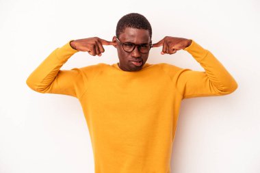 Genç Afrikalı Amerikalı bir adam beyaz arka planda izole edilmiş parmaklarıyla kulaklarını kapatan, yüksek sesli bir ortam tarafından stresli ve umutsuz..