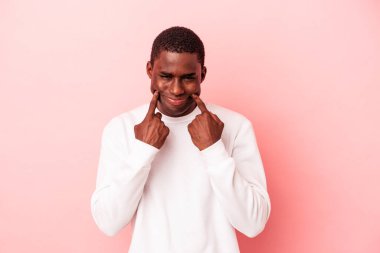 Genç Afrikalı Amerikalı iki seçenek arasında kuşkuyla pembe arka planda izole edilmiş..