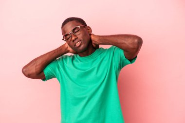Genç Afrikalı Amerikalı bir adam pembe arka planda izole edilmiş kafasının arkasına dokunuyor, düşünüyor ve bir seçim yapıyor..