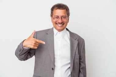 Middle aged indian business man isolated on white background person pointing by hand to a shirt copy space, proud and confident
