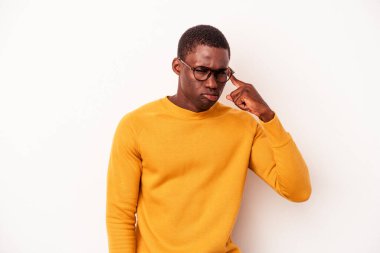 Beyaz arka planda izole edilmiş genç Afro-Amerikan bir adam şakağı parmağıyla işaret ediyor, düşünüyor ve bir göreve odaklanıyor..