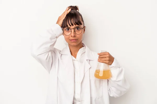 Young mixed race scientist woman holding a test tube isolated on white background  being shocked, she has remembered important meeting.