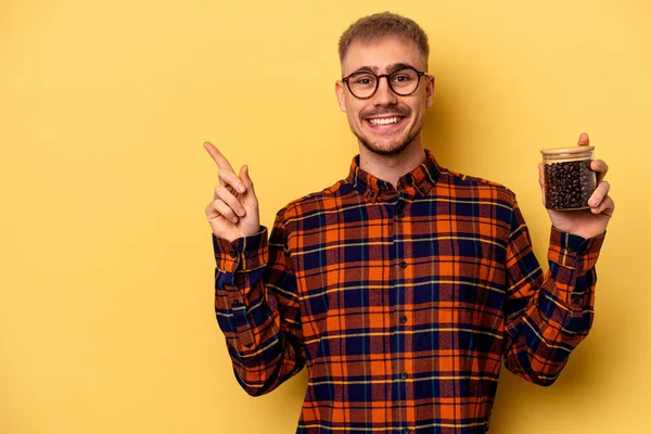 Young Caucasian Man Holding Coffee Jar Isolated Yellow Background Smiling — Photo