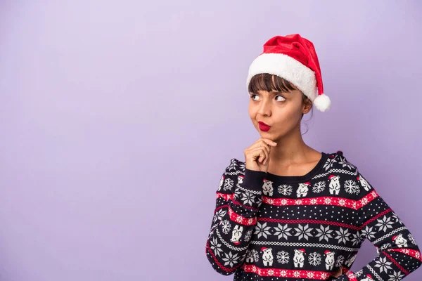 크리스마스를 축하하는 보라색 배경에 고립되어 의심스럽고 회의적 표정으로 — 스톡 사진