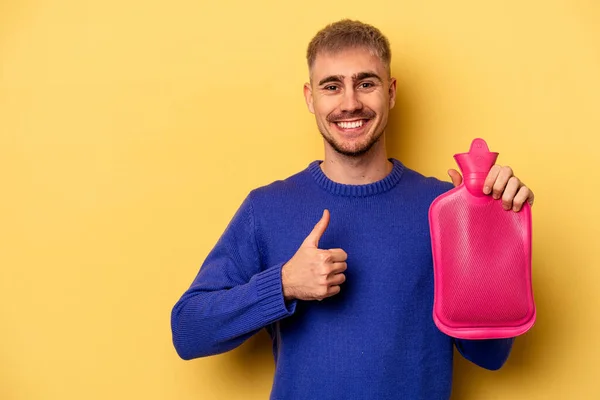 Young Caucasian Man Holding Water Bag Isolated Yellow Background Smiling — Fotografia de Stock