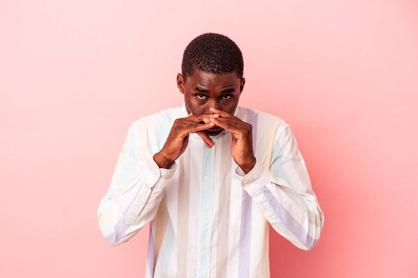 Young African American man isolated on pink background making up plan in mind, setting up an idea.