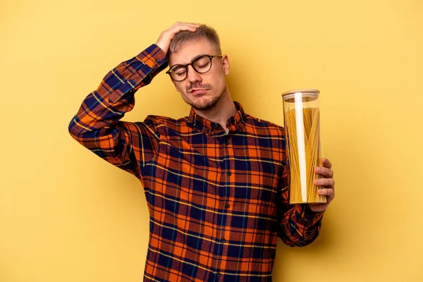 Young Caucasian Man Holding Spaghettis Jar Isolated Yellow Background Being — Stock Photo, Image